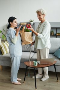 Nurse Delivering Groceries to Senior Woman